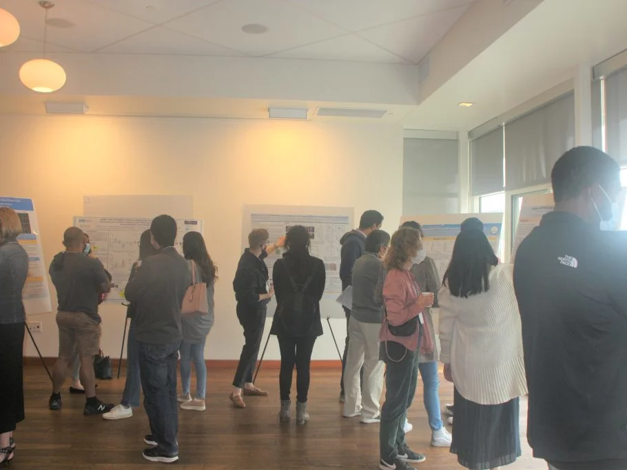 Graduate students and faculty looking at posters depicting department research
